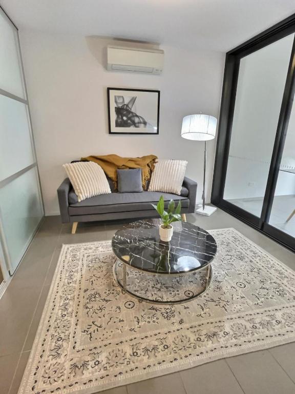 a living room with a couch and a table at Modern 1BR Views in Belconnen in Belconnen