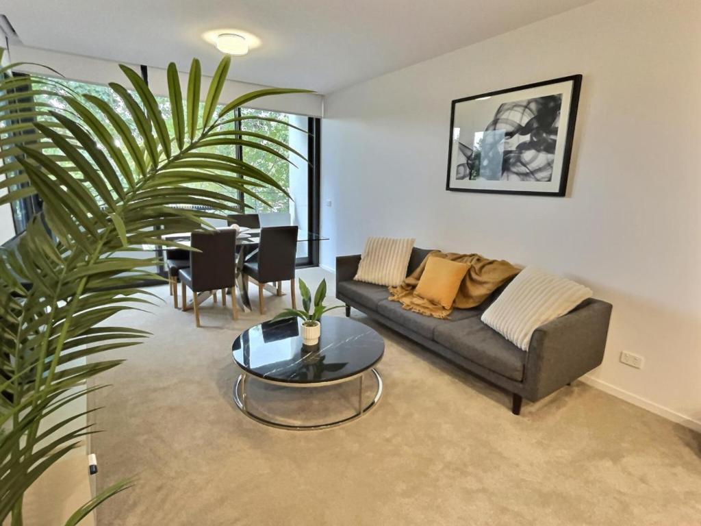 a living room with a couch and a table at Balcony Apt with 1 Bedroom in Belconnen