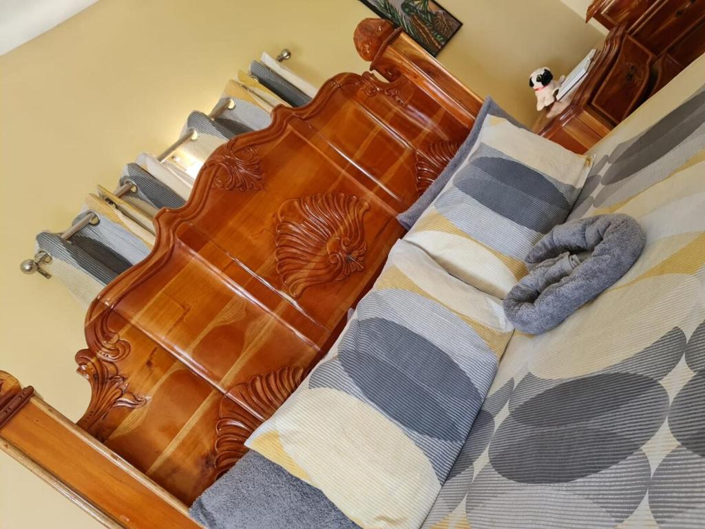 a bed with a wooden headboard and pillows on it at Round Hill View Heights in Pedro Cross