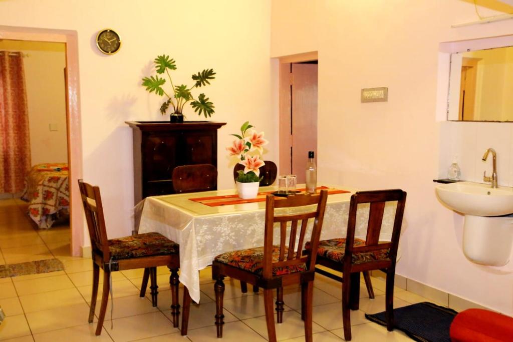 a dining room with a table and chairs and a sink at Alleppey La Casa in Alleppey