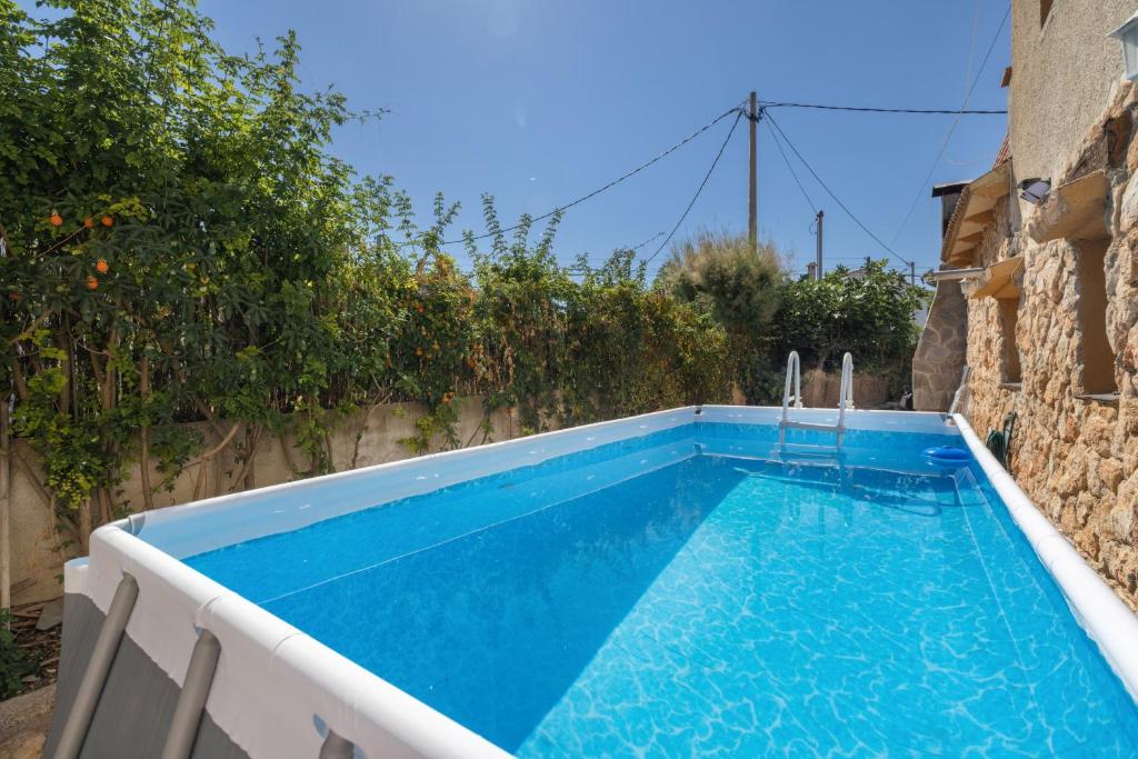a swimming pool with blue water in a backyard at Villa Sueños Piscina Costa Dorada in Calafell