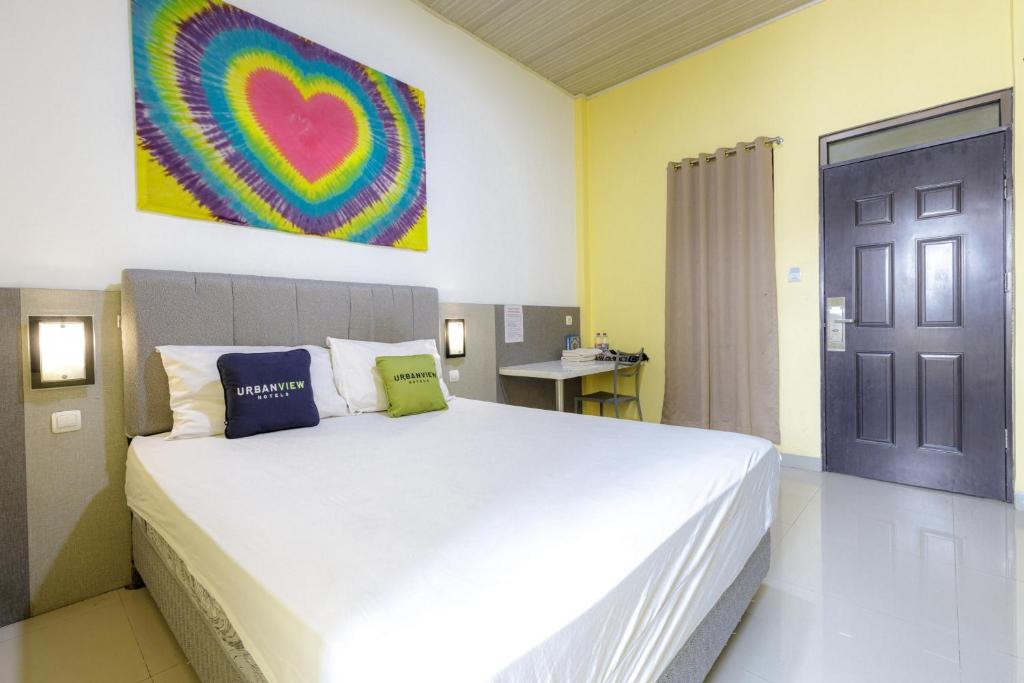 a bedroom with a large bed and a black door at Urbanview Hotel Delima 101 Syariah in Serang