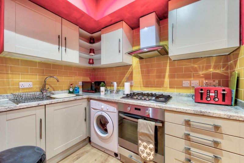 a kitchen with a sink and a washing machine at Edinburgh Central Drumdryan ApartHotel in Edinburgh