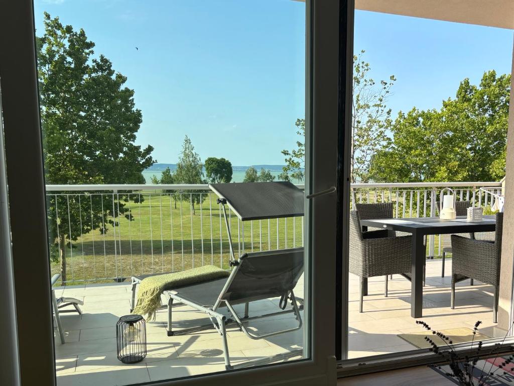 a balcony with a view of a table and chairs at Panorama Apartman Zamardi in Zamárdi