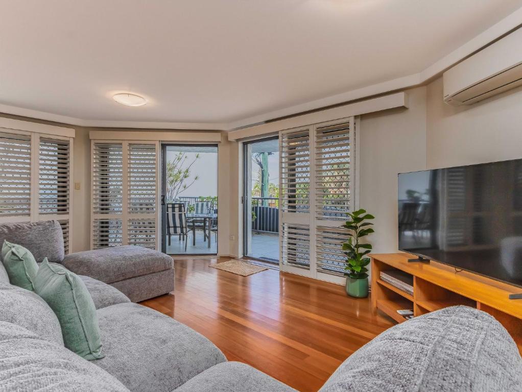 a living room with two couches and a flat screen tv at Breakwater Views Apartment 2 Cabarita Beach in Cabarita Beach