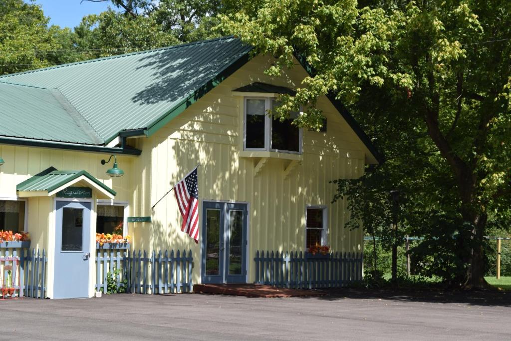 納許維爾的住宿－綠谷汽車旅館，上面有美国国旗的黄色房子