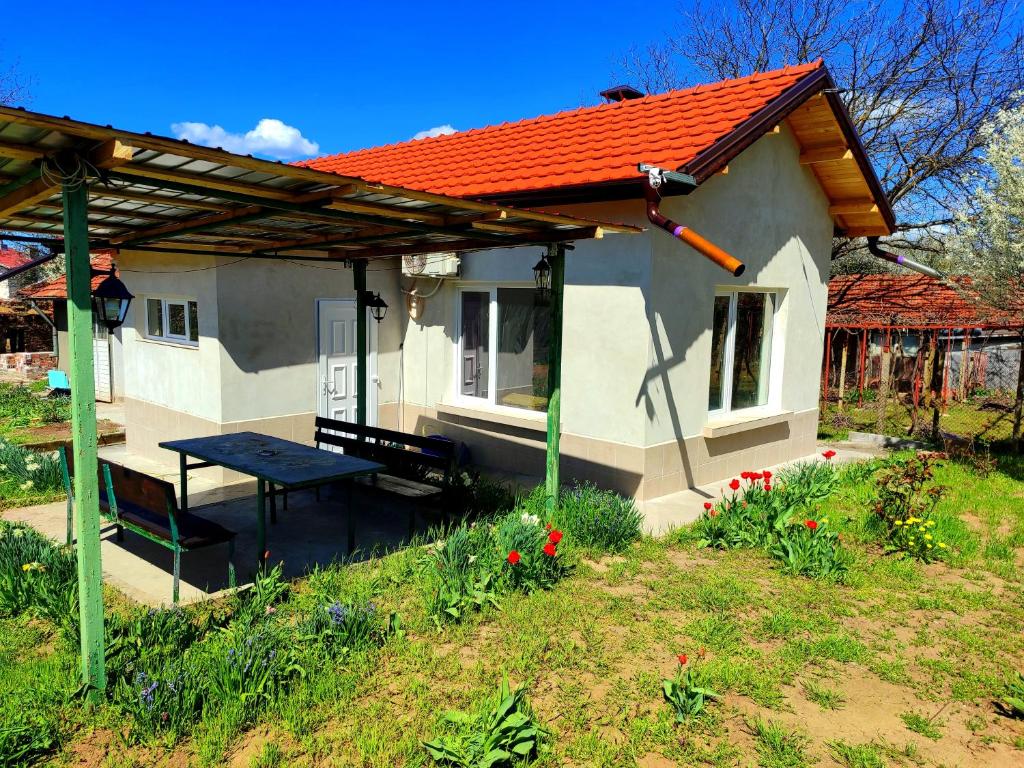 a small house with a picnic table and a bench at Goranovi House in Pleven