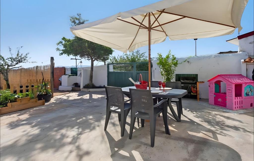 a table and chairs with an umbrella on a patio at Casinha do coração do Oeste in Cadaval