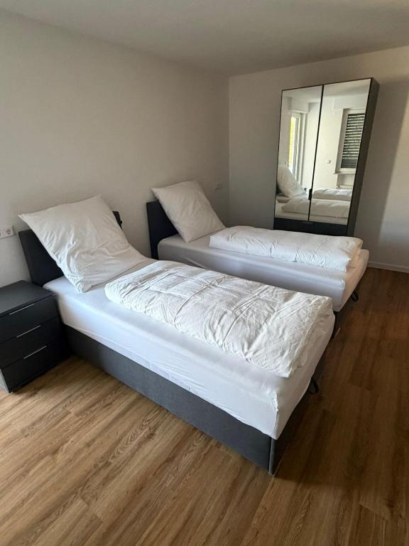 two beds in a room with a mirror at Bayman Apartments in Ellhofen