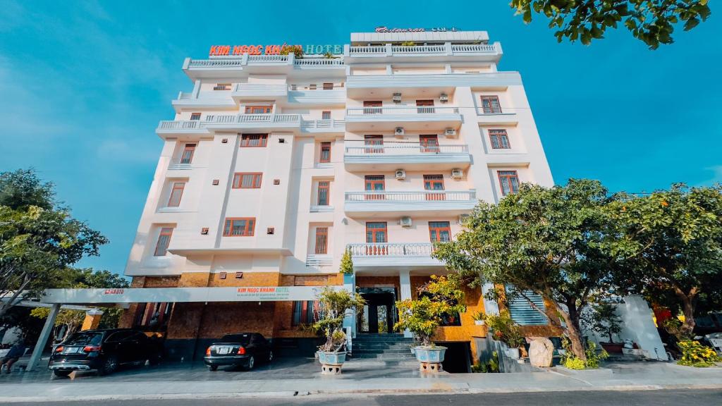 a large white building with cars parked in front of it at Kim Ngoc Khanh Hotel in Tuy Hoa