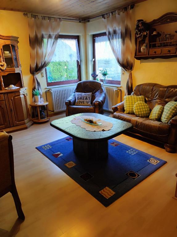 a living room with a table and a couch at Ferienwohnung Waldblick in Langenfeld