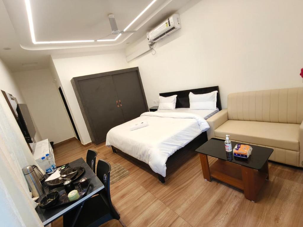 a room with a bed and a couch and a table at Hotel 7 dreamers in Vākalapūdi