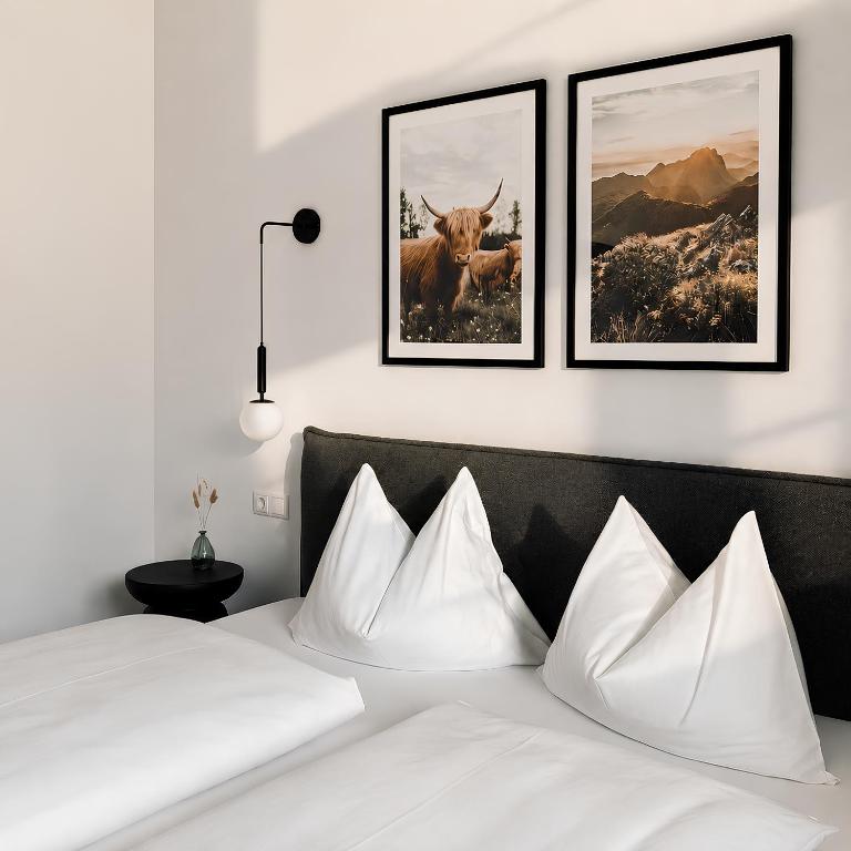 a bedroom with a bed with three pictures on the wall at Levio Homes Sunny Alpine Apartments with Balconies in Haus im Ennstal