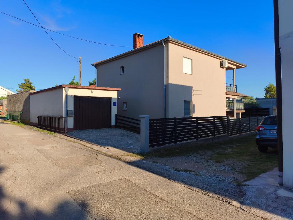 a white house with a garage and a fence at Mandica in Seline