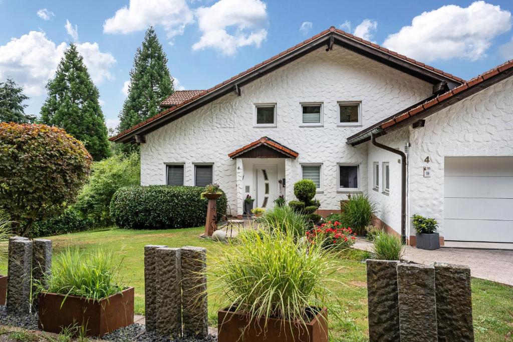 a white house with a garage at Ferienglück Vogelsang in Loßburg