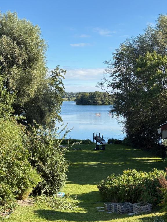 a park with a bench and a view of a lake at Seehaus Plön in Plön