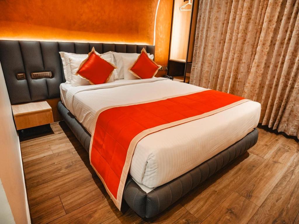 a large bed in a hotel room with red pillows at Crown Residency in Kanyakumari