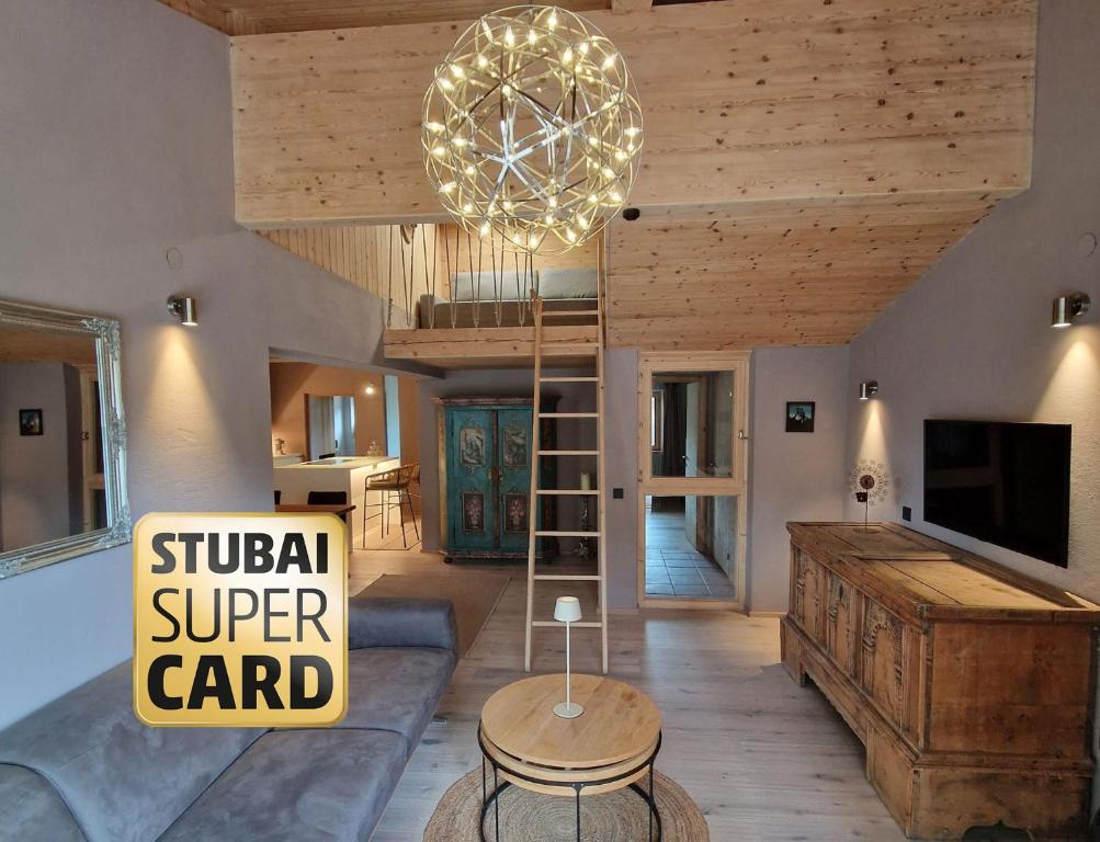 a living room with a couch and a chandelier at chalet atelier Luxuriöses Chalet mit alpinem Charme in Telfes im Stubai