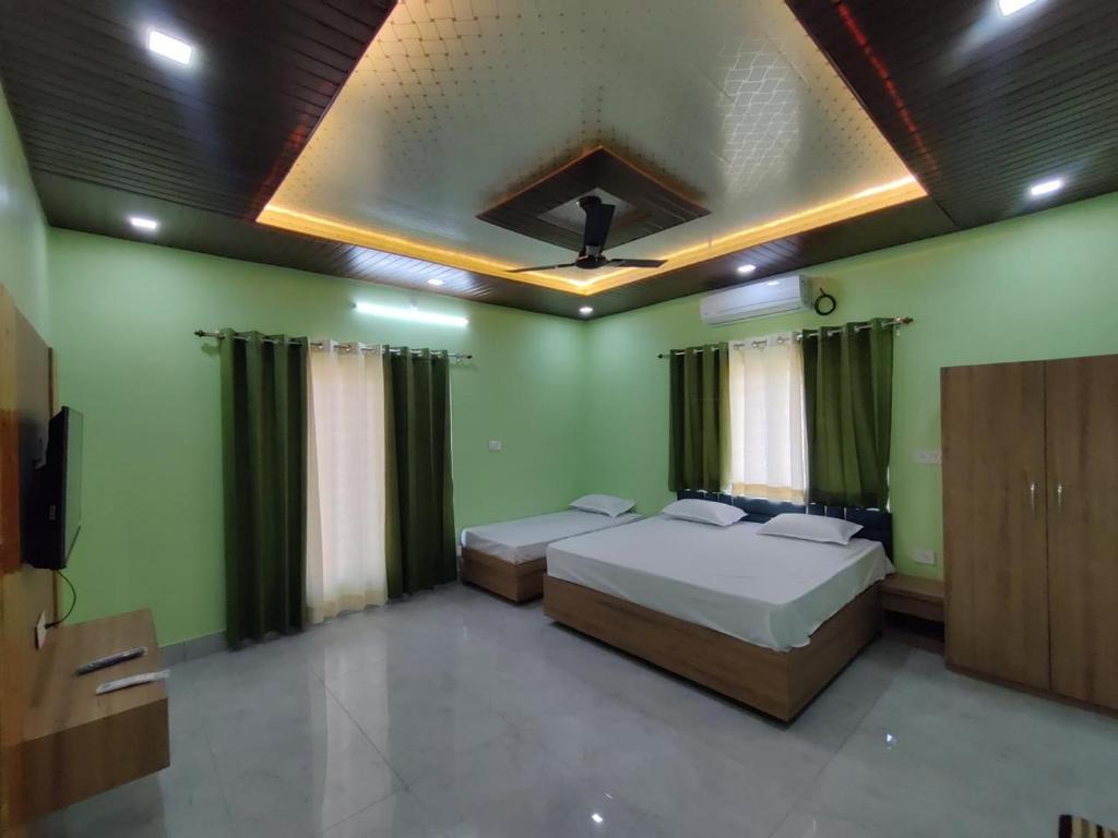 two beds in a room with green walls at M2 lambardaar in Dehradun