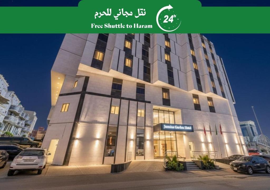 a tall building with cars parked in a parking lot at Jasmine Garden Makkah in Al Masfalah