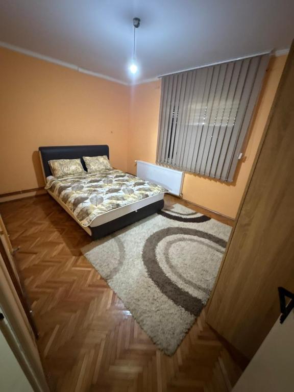 a bedroom with a bed and a window and a rug at Marinel in Vršac