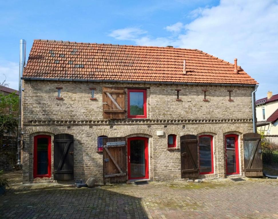 an old brick building with red doors and a red roof at Rotes Haus im Havelland in Phöben