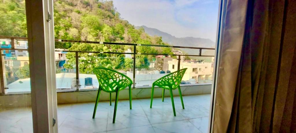 two chairs on a balcony with a view of a mountain at Yogvan Luxury 1BHK Apartments Tapovan Rishikesh in Rishīkesh