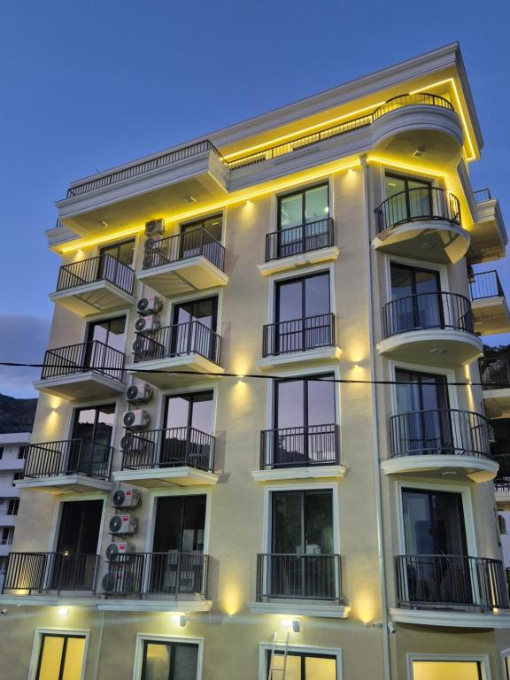 a white building with balconies and lights on it at Majestic Bay in Čanj
