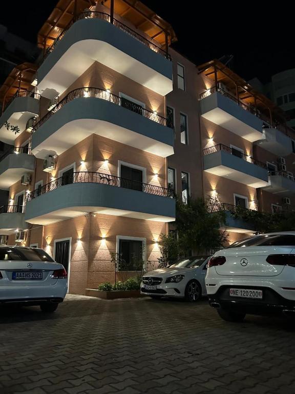 a large building with cars parked in front of it at Villa Klinton in Durrës