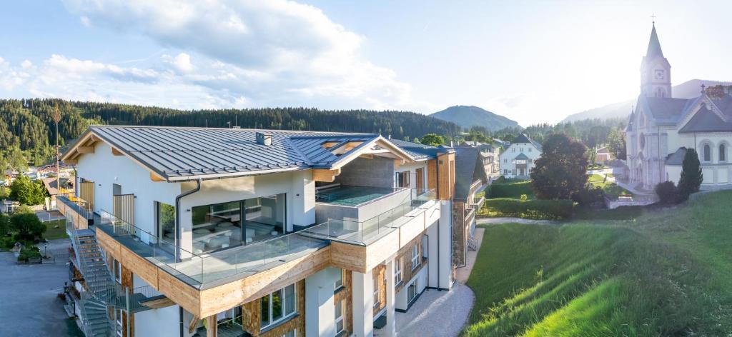 an aerial view of a house with a church at Hotel Pehab - Rooftop-Spa in Ramsau am Dachstein