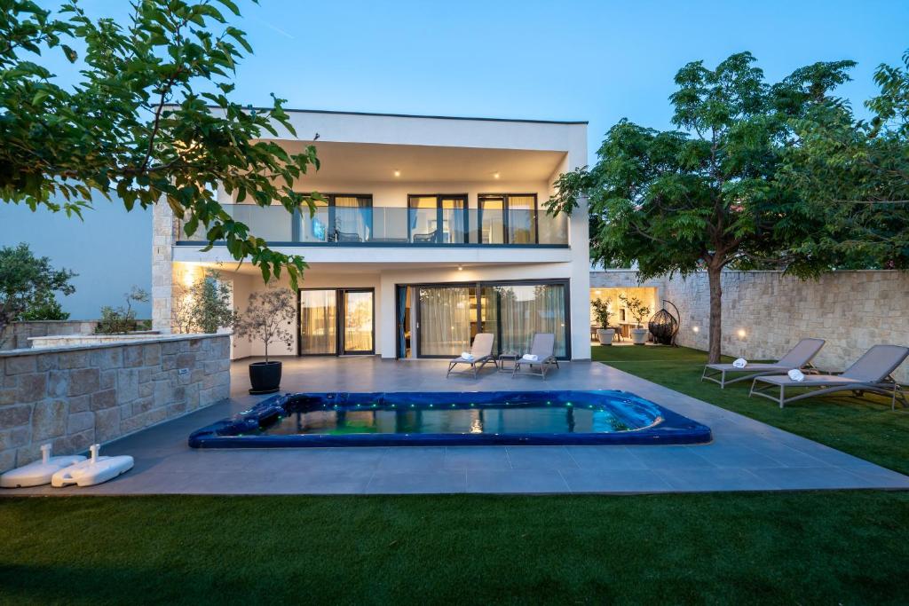 a house with a swimming pool in the yard at Vila Marila in Stara Novalja