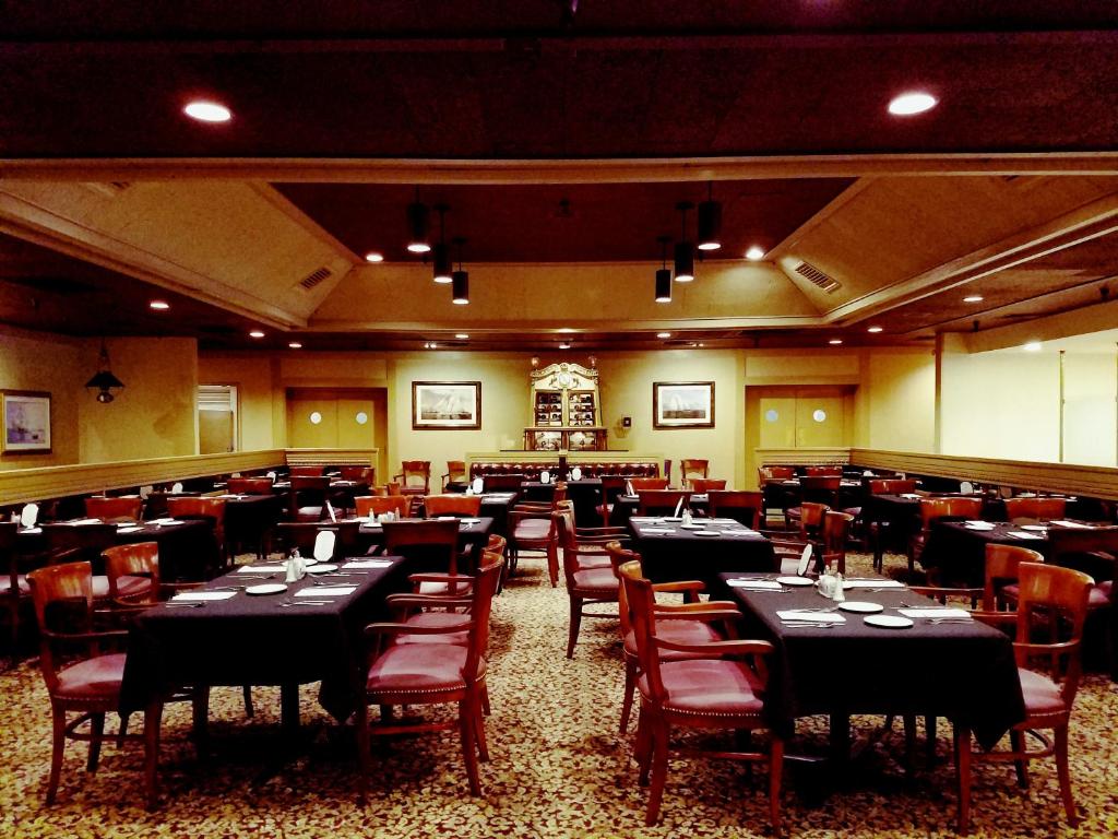 a dining room filled with tables and chairs at Piccadilly Inn Airport in Fresno