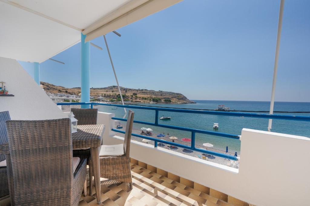 a balcony with a table and chairs and the ocean at Dorothy's Seaview Apartment in Haraki