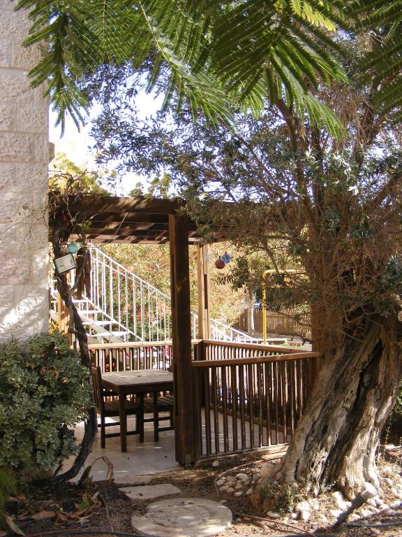 a wooden porch with a bench and a tree at Nof Canaan in Kfar Adumim