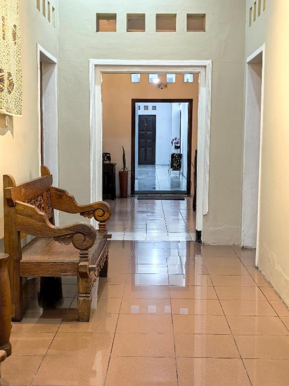 a hallway with a bench and a hallway leading into a building at Santalum Hotel Yogyakarta in Yogyakarta