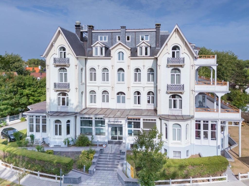 an aerial view of a large white building at HI Hostel Dunepanne in De Haan
