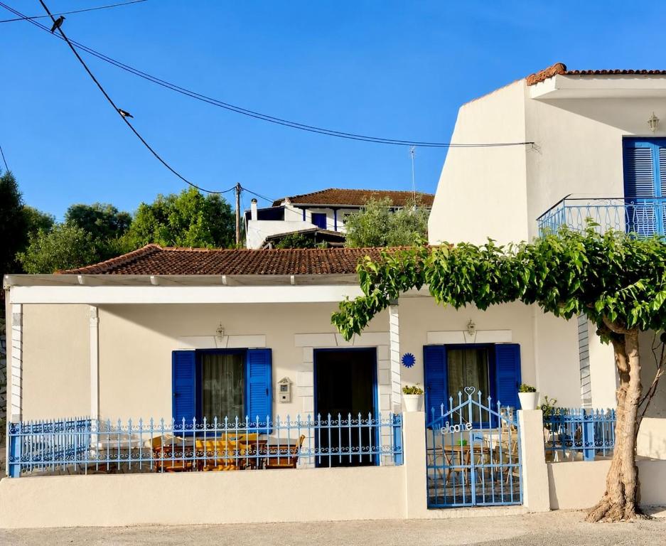a white house with a blue fence at Joanna Seaside House in Meganisi