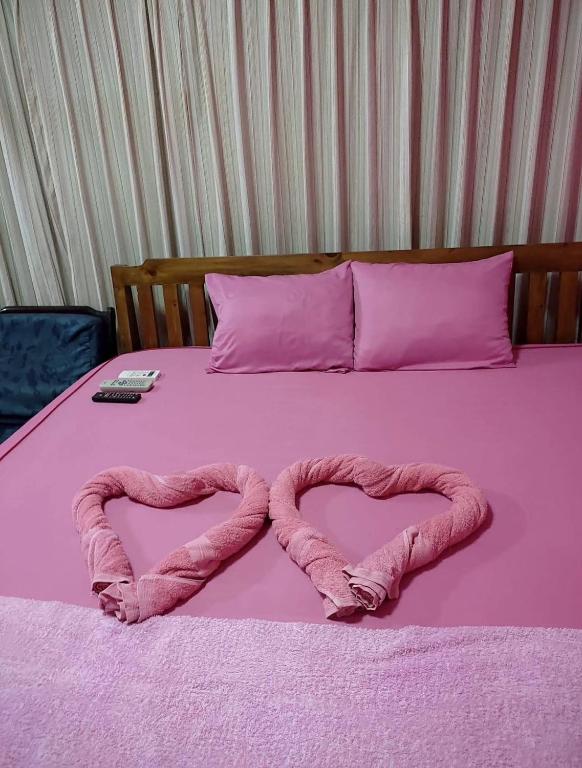 a pink bed with two pink hearts on it at ชมภูนุช ห้องพัก เกาะล้าน in Ko Larn