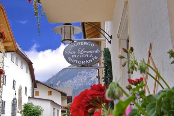 um sinal num edifício com uma montanha ao fundo em Hotel San Leonardo em Badia