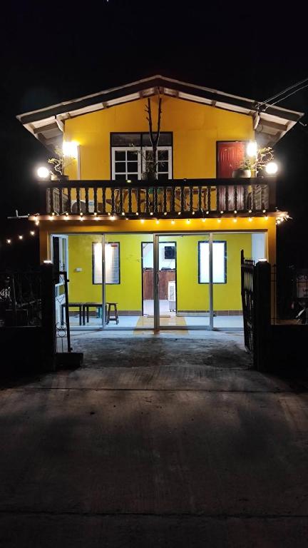 a yellow building with a balcony at night at Laena Homestay in Ko Yao Noi
