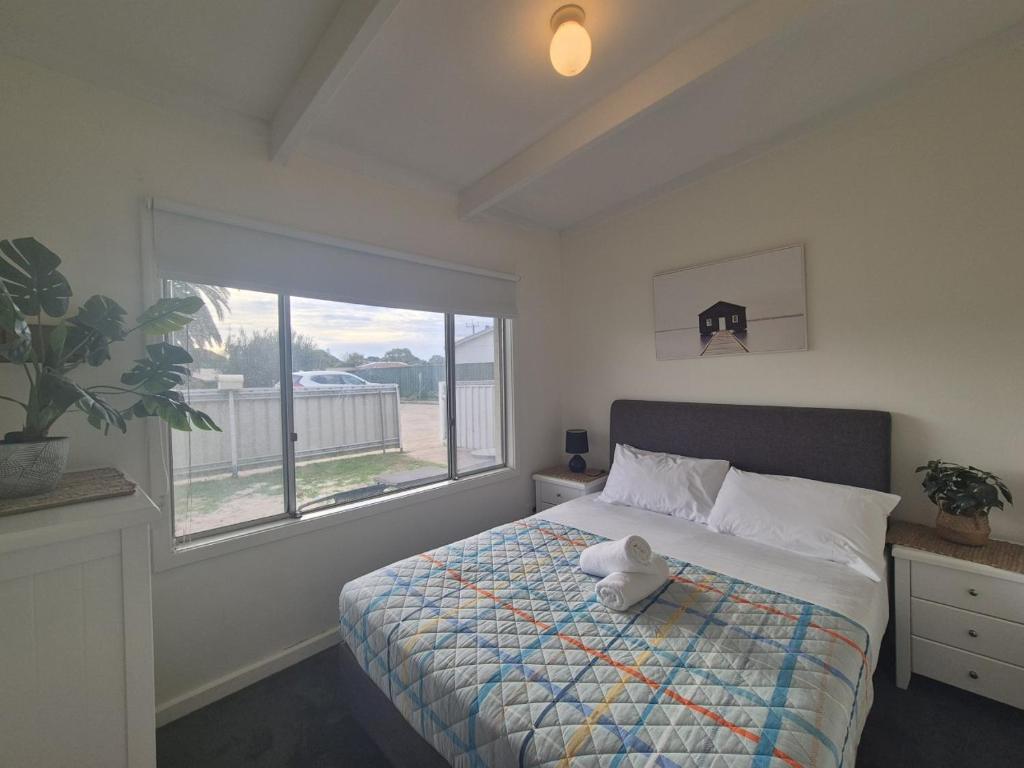 a bedroom with a bed with a teddy bear on it at Esperance Little Units 2 in Esperance