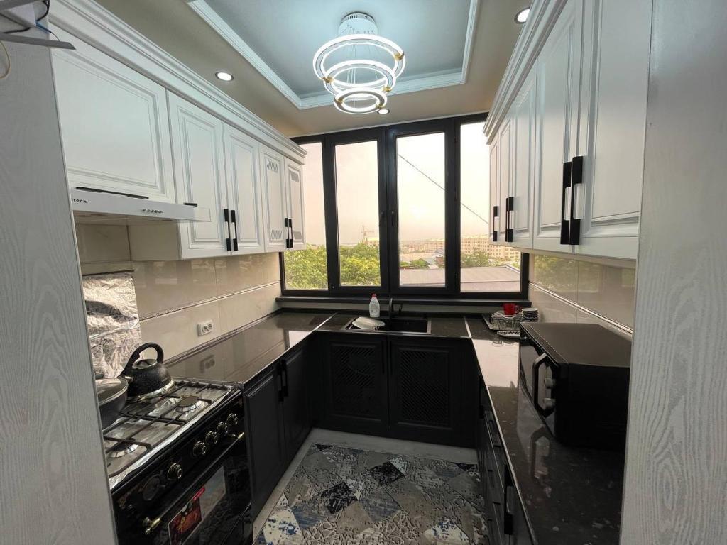 a kitchen with white cabinets and a stove top oven at Квартира in Samarkand