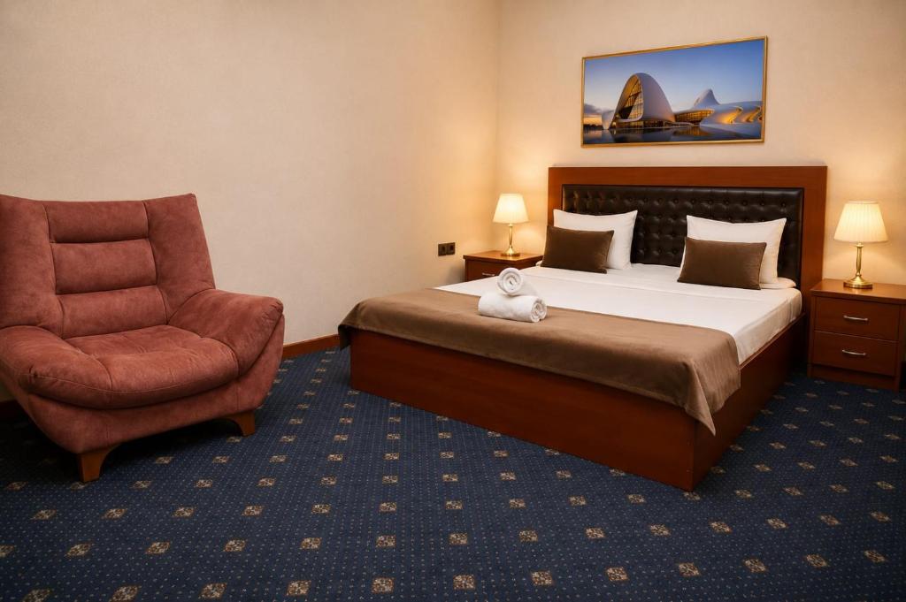 a hotel room with a bed and a chair at Porto Bistro in Baku