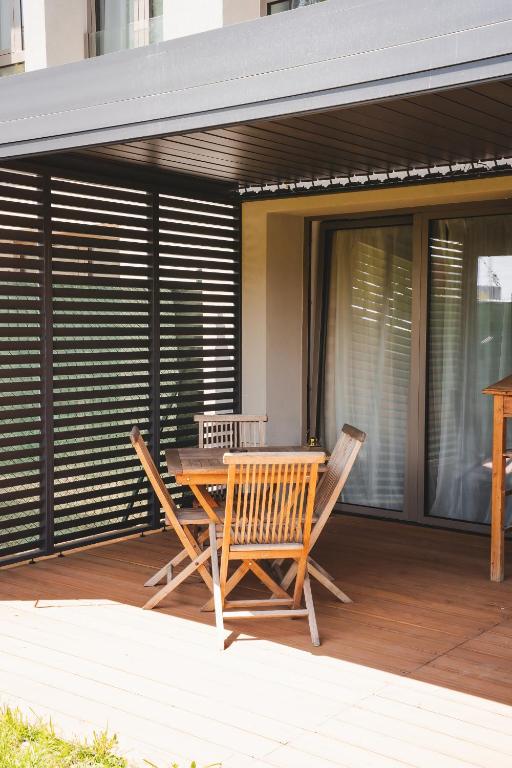 a patio with a table and chairs on a deck at Pioneer house - app with free parking place, terrace and private garden in Koliba