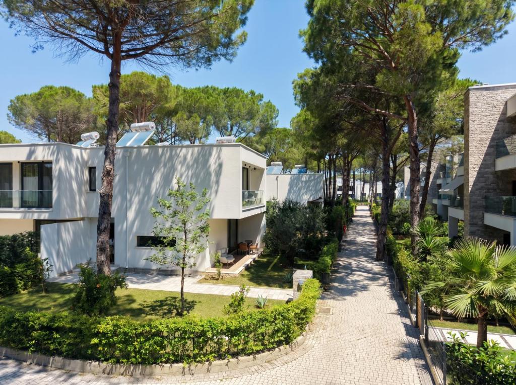 a walkway in front of a building with trees at Seaside Premium Villa in Lalzit Bay
