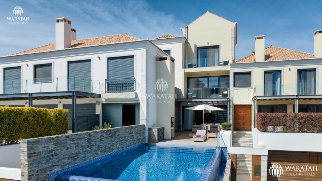 a villa with a swimming pool and a house at Emily in Vale do Lobo