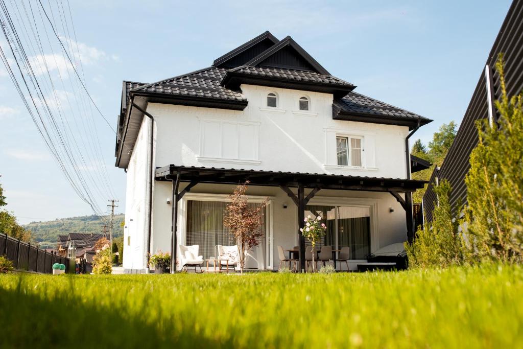 a white house with a black roof at Ina Deluxe in Moisei
