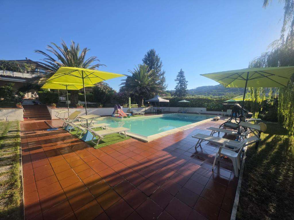 a swimming pool with umbrellas and chairs and a pool at Villa Serena in Assisi