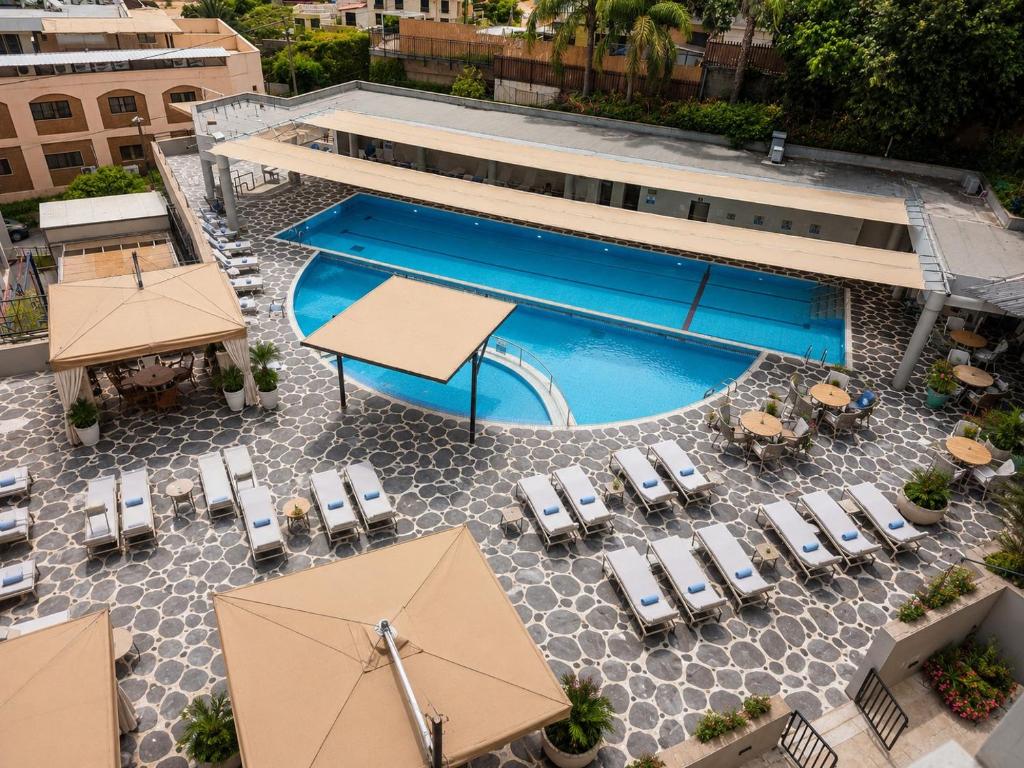 an overhead view of a pool with chairs and umbrellas at Royal Plaza Hotel in Tiberias