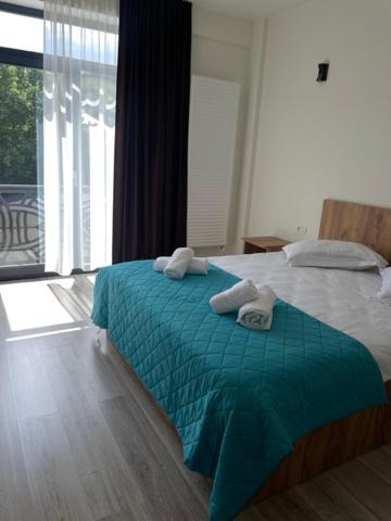 a bedroom with a bed with two towels on it at LA MĂRIUCA camere de inchiriat in Moineşti